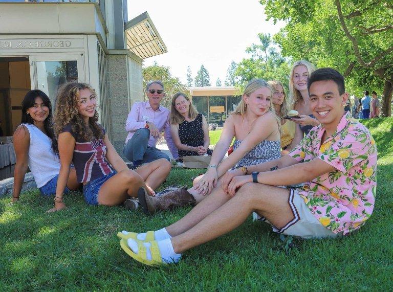 president strom and wife isabel sit with six students on the mounds